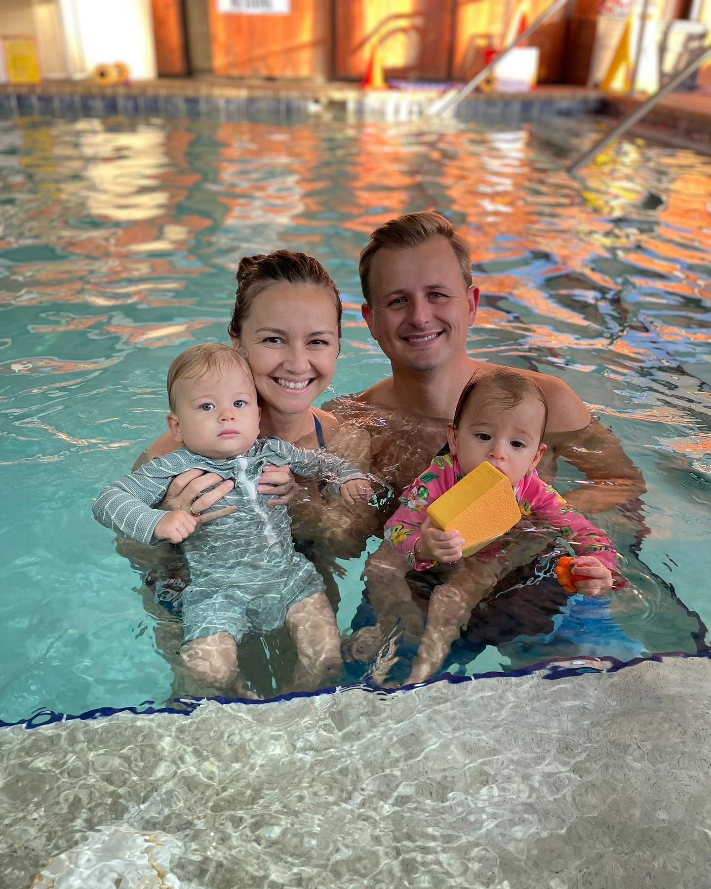 A family is swimming in the pool together.