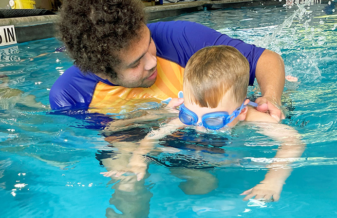 A man teaching a child how to swim.