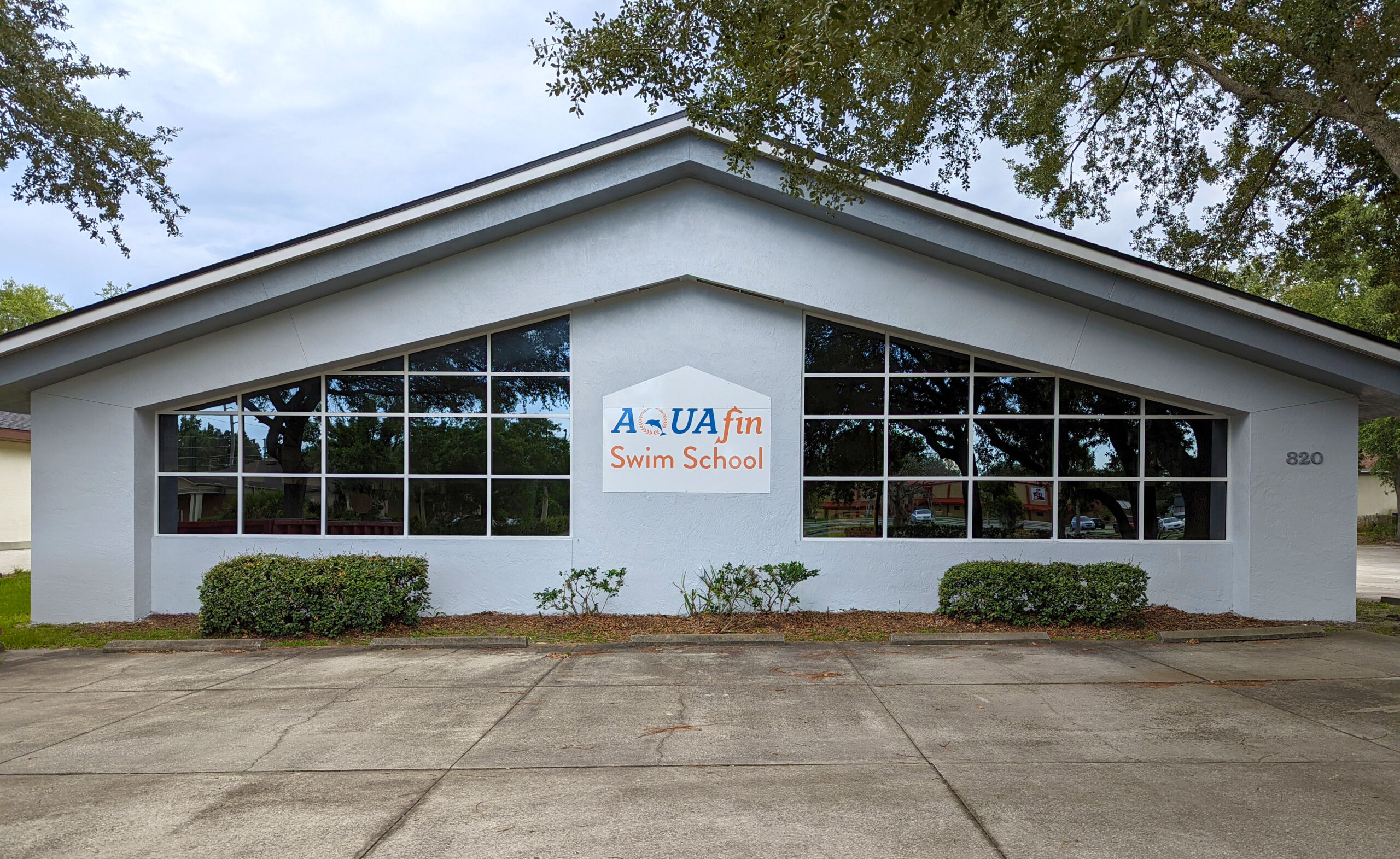A white building with a sign on the front of it.