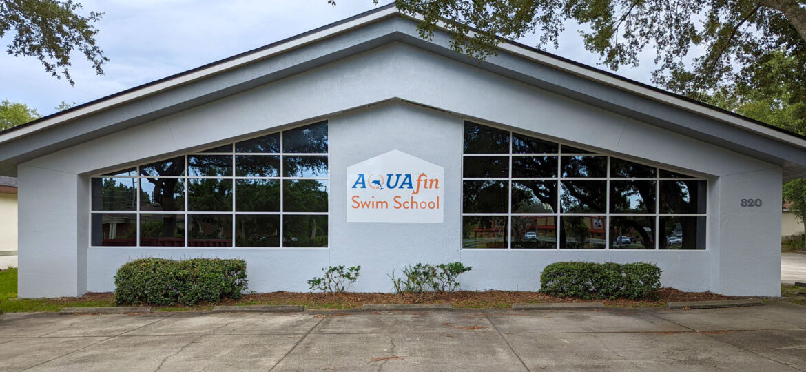 A white building with a sign on the front of it.