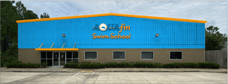 A building that reads " aqua fin swim school ".